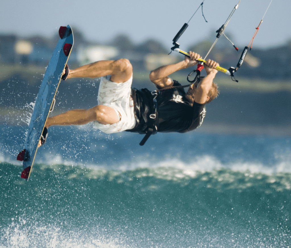 Kitesurfer performing aerial trick over water